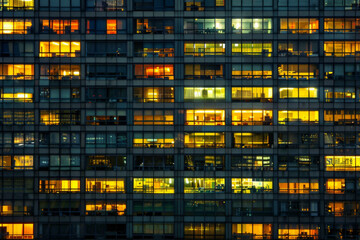 An office building at night, filled with glowing windows like the lights of an urban cityscape, captures the symmetrical arrangement and grid effect. 