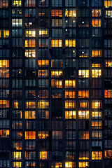 An office building at night, filled with glowing windows like the lights of an urban cityscape, captures the symmetrical arrangement and grid effect. 