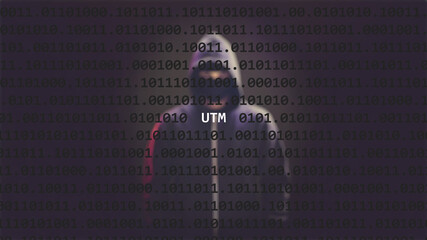 Cyber attack utm text in foreground screen, anonymous hacker hidden with hoodie in the blurred...