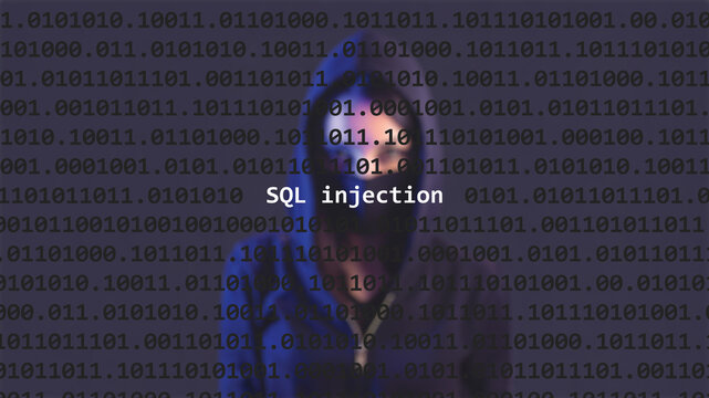 SQL injection text in foreground screen, anonymous hacker hidden with hoodie in the blurred background. Vulnerability text in binary system code on editor program.