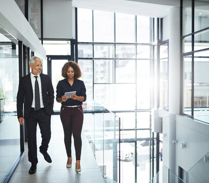 Business people, mentor and employee waling with tablet for advice, help and communication in office. Senior manager, teamwork and intern support for growth, learning and questions with lens flare