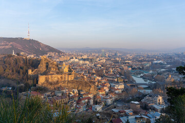 Obraz premium Sunrise in the city. Narikala fortress, mosque, Metekhi church, TV tower, Mtkvari river. Tbilisi, Georgia