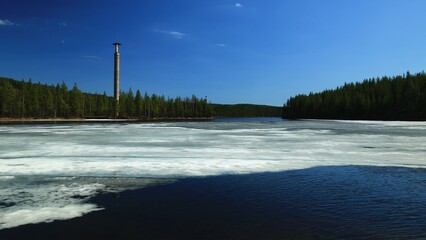 Idyllic Swedish landscape with melting ice and old concrete pillars in the forest