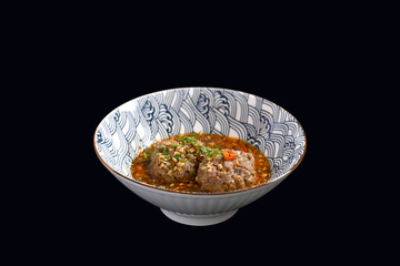 Scalded meatballs in spicy soup isolate on black background. Asian food