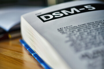 Open DSM-5 Book on Wooden Table