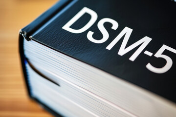 Close-Up of the DSM-5 Book Spine on a Wooden Surface