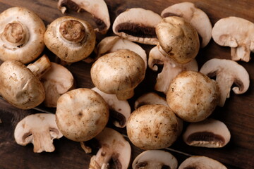 champignons are edible mushrooms that are almost round like buttons. mushroom is the most widely cultivated mushroom in the world. Agaricus bisporus. served on a rustic wooden table. 