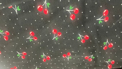 Black fabric pattern with a red cherry pattern