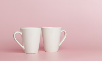white cups for tea or coffee on a pink background
