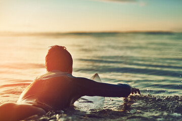 Sunset, boy or surfer on surfboard at sea fitness training, workout or sports exercise in...