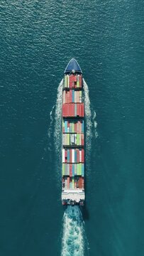 Vertical Screen: This breathtaking vertical aerial image showcases a container ship at sea filled with cargo containers, ideal for shipping, logistics, maritime themes, and freightrelated content