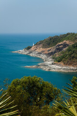 an open field next to the ocean and some trees in the foreground