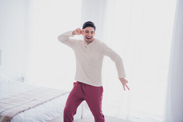 Photo of cheerful active glad man wearing trendy pajama dancing celebrating weekend time vacation...