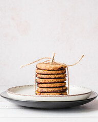 Several homemade cookies stacked and tied with a jute string. Elegant and minimalist food concept.
