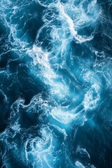 Fototapeta premium the ocean waves are churning in a dark blue sea, with one wave slightly left