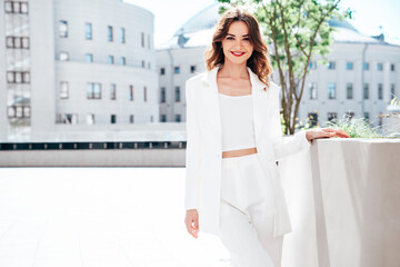 Young beautiful brunette woman wearing nice trendy white suit jacket. Sexy smiling model posing in...