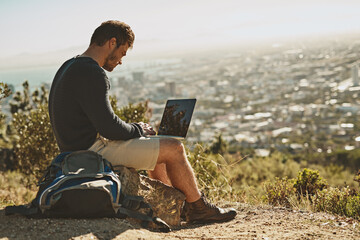 Exploration, man and hiker with laptop outdoor for remote work, connection and location review. Male person, freedom and computer in nature for typing, research and planning adventure blog or website © C Pendl�/peopleimages.com