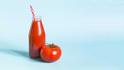 A banner of tomato juice in a glass bottle with a red tube and a juicy tomato in close-up on a...