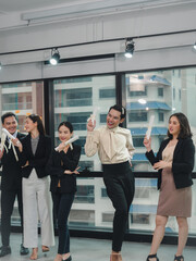 Fototapeta premium Group of businesspeople with diverse genders (LGBT) celebrate faked business certificates together in the meeting room. Business people teamwork..