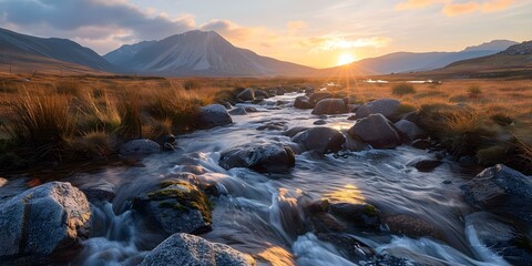 Obraz premium Flowing Stream with Sunlit Mountain Range View. Concept Landscapes, Mountains, Nature Photography, Scenic Views