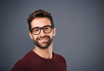 Obraz premium Studio, glasses and man with portrait, confident and wellness with eye care, product and lens for vision. Black background, face and happiness for person, prescription and eyewear with fashion in USA