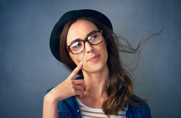 Woman, hat and happy in studio with thinking of idea for problem solving, solution or planning with...