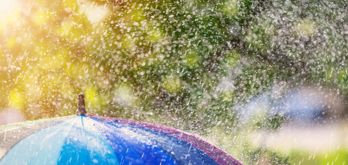 Closeup view of the colourful umbrella in rainy weather.