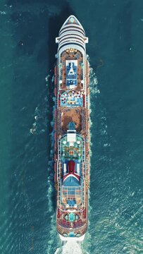 Vertical Screen: A vertical screen displays stunning aerial footage of a large cruise ship traversing the ocean, offering a topdown view of its deck and luxurious amenities in a panoramic perspective