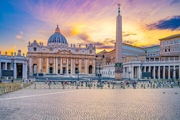 A beautiful view of St. Peters Square in Vatican City at sunset, with the iconic St. Peters...