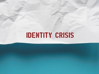 Crumpled paper on blue copy space background with handwriting IDENTITY CRISIS,period of uncertainty or confusion in life which occurs when a person becomes insecure and unstable