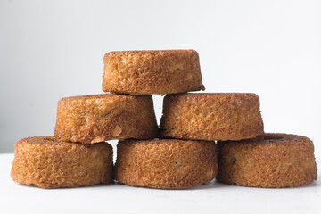 A stack of mini vanilla cakes, vanilla bundlette stacked on a white background, homemade small vanilla bundt cakes