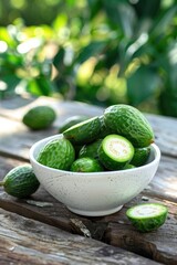 feijoa in a white bowl on a wooden table, nature background. Selective focus