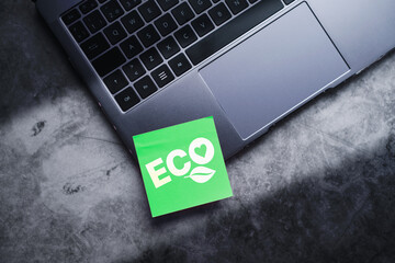 Flat lay photo of green adhesive note on laptop with ECO life text. Save the planet. Energy...