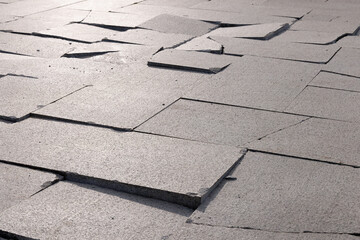 Close-up of fractured granite sidewalk tiles with shallow depth of field.