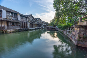 Obraz premium Discover China Wuzhen's ancient architecture, where old stone paths and bridges reflect on peaceful waters. Experience the charm of historic buildings along serene rivers..