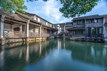 Obraz premium Discover China Wuzhen's ancient architecture, where old stone paths and bridges reflect on peaceful waters. Experience the charm of historic buildings along serene rivers..