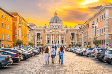 A group of tourists walk towards the Vatican City along the Road of Conciliation during a golden...