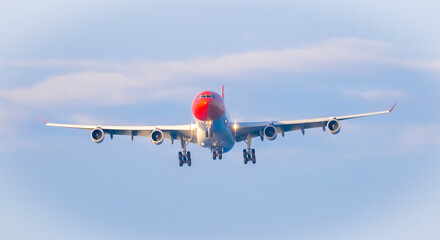 The plane lands over the sea at Phuket airport. A passenger plane lands on Mai Khao Beach, a popular tourist attraction.