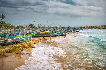 Colorful traditional wooden fishing boats moored on the tropical beach