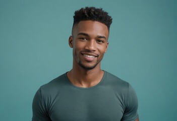 Obraz premium A confident man smiling casually in a green t-shirt. The simple setting highlights his approachable demeanor.