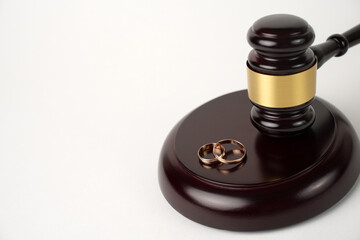 Judge gavel and Wedding rings on white background with copy space, close-up.