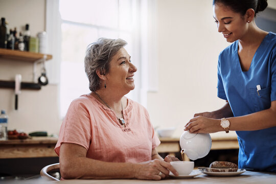 Caregiver, smile and woman with tea in nursing home kitchen for breakfast, relax or healthy nutrition of support. Nurse, patient and food for senior care with helping, trust or serving at retirement