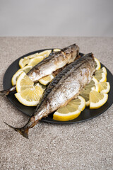 Oven-baked mackerel sea fish dish served with fresh lemon slices