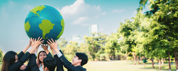 Earth day concept with big Earth globe held by group of asian business people team promoting...