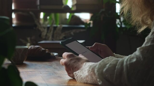 Person paying online using bank card and smartphone indoors