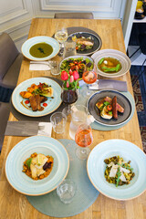 High angle view of a restaurant dining table with variety of gourmet dishes and fine wines