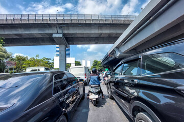 Car and motorbike drivers are waiting for the red light during the day