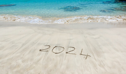The year 2024 written in the sand at the beach