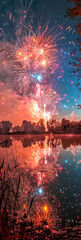 A fireworks display is lit up in the night sky, with the colors of red, orange
