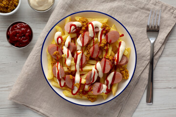 Homemade Salchipapa Fries with Ketchup, Mustard and Mayo on a Plate, top view.